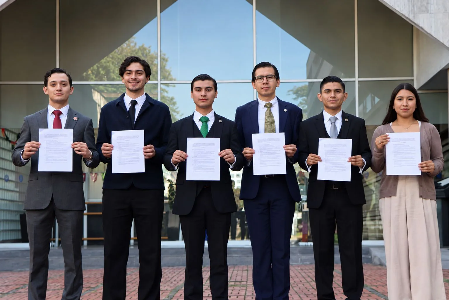 Seis estudiantes de Derecho sosteniendo los convenios firmados con la Universidad Autónoma de Nuevo León